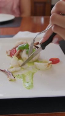 İki genç İtalyan kadın mutfaktaki masada yemek yiyorlar.