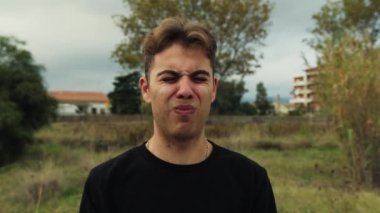 Doğada farklı yüz ifadeleri yapan bir çocuk..