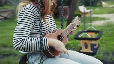 Mutlu kız doğada gitar çalıyor..