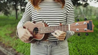 Mutlu kız doğada gitar çalıyor..
