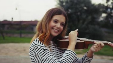 Mutlu kız doğada gitar çalıyor..