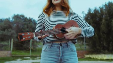 Mutlu kız doğada gitar çalıyor..