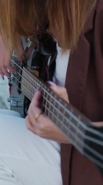 Sahilin yanındaki doğada bas gitar çalan bir kız..