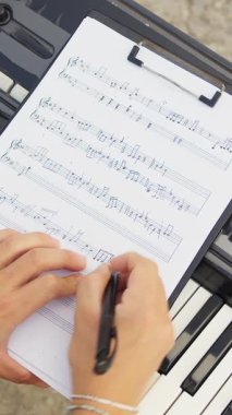 Beyaz gömlekli çocuk dışarıdaki doğada piyano çalıyor..