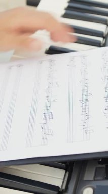 Beyaz gömlekli çocuk dışarıdaki doğada piyano çalıyor..