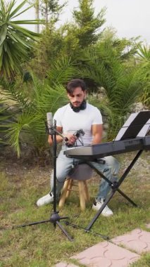 Beyaz gömlekli çocuk dışarıdaki doğada piyano çalıyor..