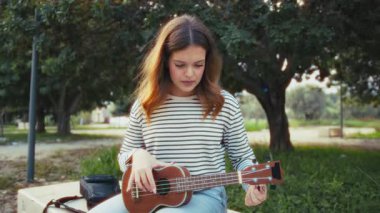 Mutlu kız doğada gitar çalıyor..