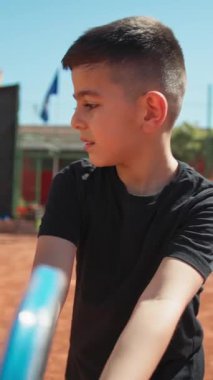 Bayan eğitmen, gündüz vakti Clay Court 'ta tenis öğretiyor..