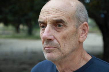 Yaşlı beyaz adam farklı bir yüz ifadesi takınıyor..