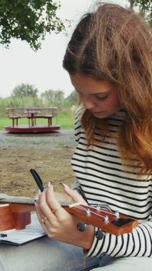 Mutlu kız doğada gitar çalıyor..