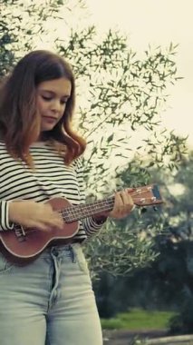 Mutlu kız doğada gitar çalıyor..