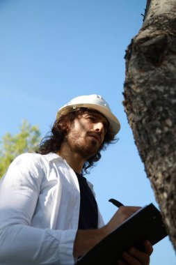  Bilimadamı, kırsal kesimdeki güzel bir ağacın gövdesinden etkilendi.. 