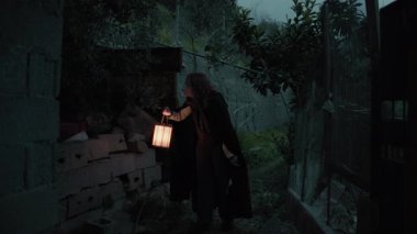 Bulutlu bir günde kırsalda pelerinli genç bir kadın..