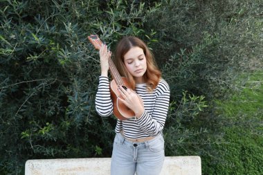 Mutlu kız doğada gitar çalıyor..