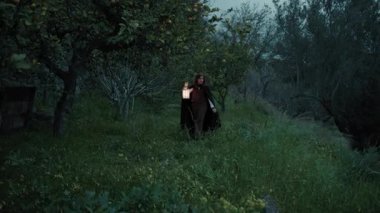 Bulutlu bir günde kırsalda pelerinli genç bir kadın..