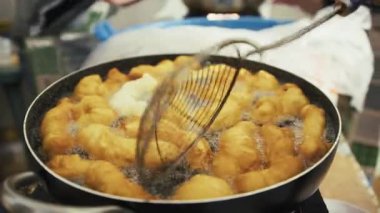 Kaynar yağla tavada Savory Zeppole kızartma.