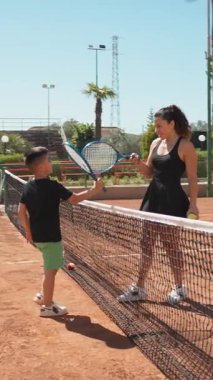 Bayan eğitmen, gündüz vakti Clay Court 'ta tenis öğretiyor..