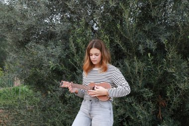 Mutlu kız doğada gitar çalıyor..