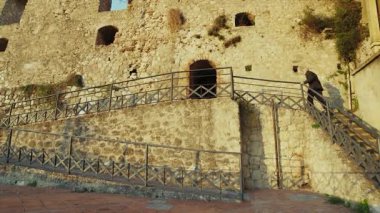 Turist, tarihi Calabrian köyündeki antik bir savunma kalesinin duvarlarını keşfediyor..