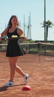 Bayan eğitmen, gündüz vakti Clay Court 'ta tenis öğretiyor..