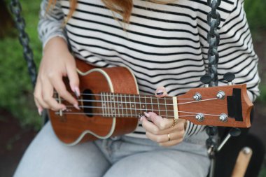 Mutlu kız doğada gitar çalıyor..