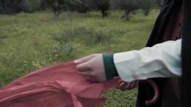 Bulutlu bir günde kırsalda pelerinli genç bir kadın..