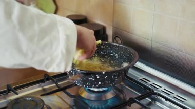 Mans Hands, patatesleri kızgın yağlı bir kaba koydu..