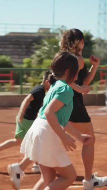 Bayan eğitmen, gündüz vakti Clay Court 'ta tenis öğretiyor..