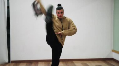 Kadın metaforik olarak kendini sorunlardan arındırmak için koridorda ruh haliyle dans ediyor..