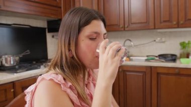 İtalyan kız evdeki mutfakta bir bardak su içiyor..