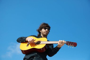 Genç Uzun Saçlı Adam Klasik Gitar Çalıyor Dışarıda, Düşük Açı.