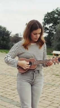 Mutlu kız doğada gitar çalıyor..