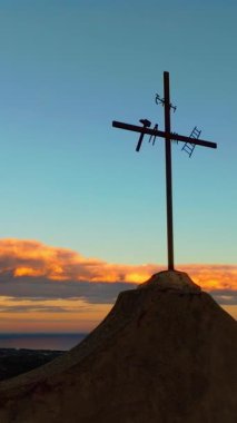 Gün batımında üç Hıristiyan haçı silueti.