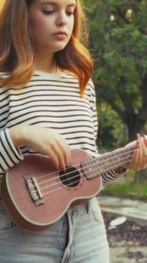 Mutlu kız doğada gitar çalıyor..