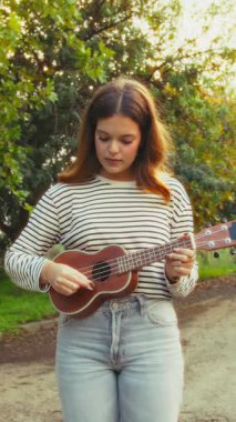 Mutlu kız doğada gitar çalıyor..