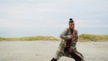 Enerjik ruh hali olan sahildeki kadın müziğin ritmiyle dans ediyor..