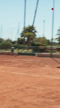 Bayan eğitmen, gündüz vakti Clay Court 'ta tenis öğretiyor..
