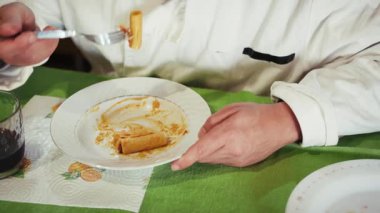 Şefin elleri alçakgönüllülükle yemekten sonra tabakta kalan makarnayı yer..