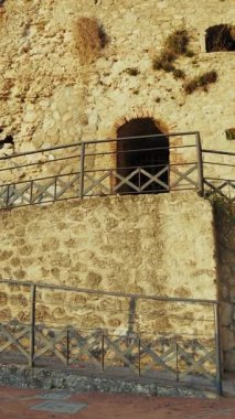 Turist, tarihi Calabrian köyündeki antik bir savunma kalesinin duvarlarını keşfediyor..