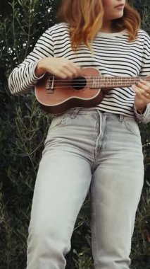 Mutlu kız doğada gitar çalıyor..