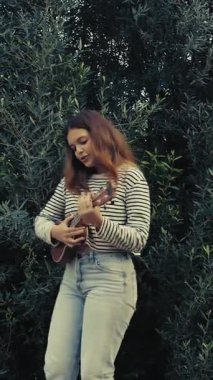 Mutlu kız doğada gitar çalıyor..