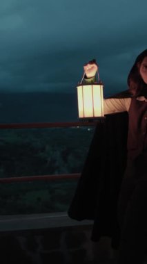 Bulutlu bir günde kırsalda pelerinli genç bir kadın..