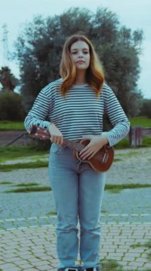 Mutlu kız doğada gitar çalıyor..