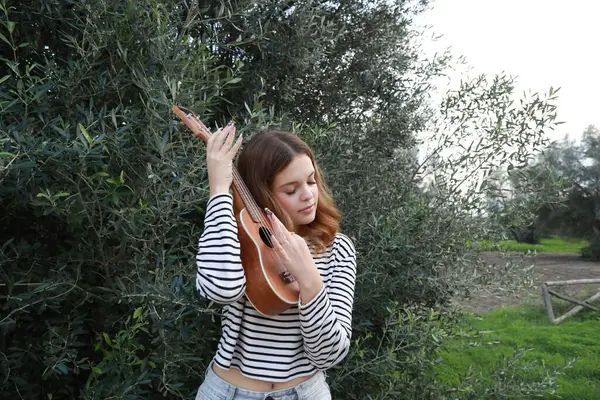 Mutlu kız doğada gitar çalıyor..