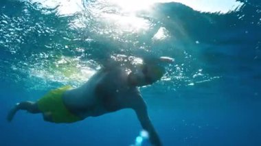 Yüzücü okyanusta güneş ışığıyla kardiyo antrenmanı yapıyor. . 