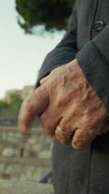 Kırsal kesimde zamanın geçişi için sabırsızlanan yaşlı bir adamın elleri.