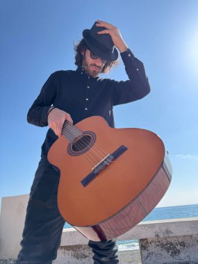 Genç adam, yazın yaya geçidinde gitar çalıyor..