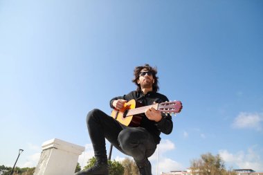 Genç Uzun Saçlı Adam Klasik Gitar Çalıyor Dışarıda, Düşük Açı.