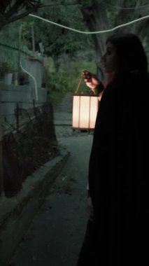 Bulutlu bir günde kırsalda pelerinli genç bir kadın..