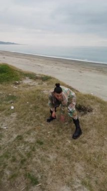 Kadın kendini iyi hissediyor ve bulutlu bir günde okyanusun kenarında dans ediyor..